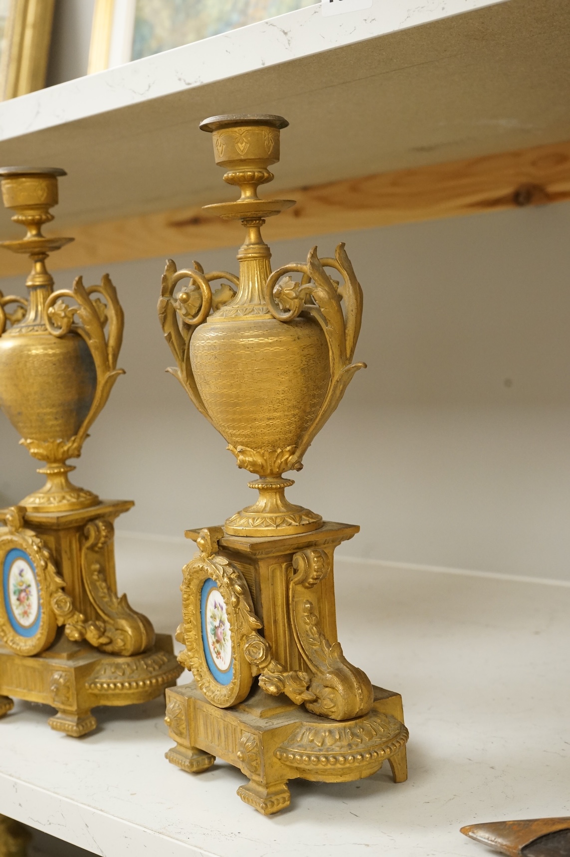A pair of 19th century gilt metal candlesticks with inset porcelain panels, 32cm high